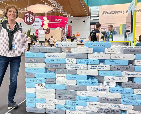 Margit an einem Ausstellerstand mit vielen Ideen von Besuchern, was zum Lernen alles dazugehört